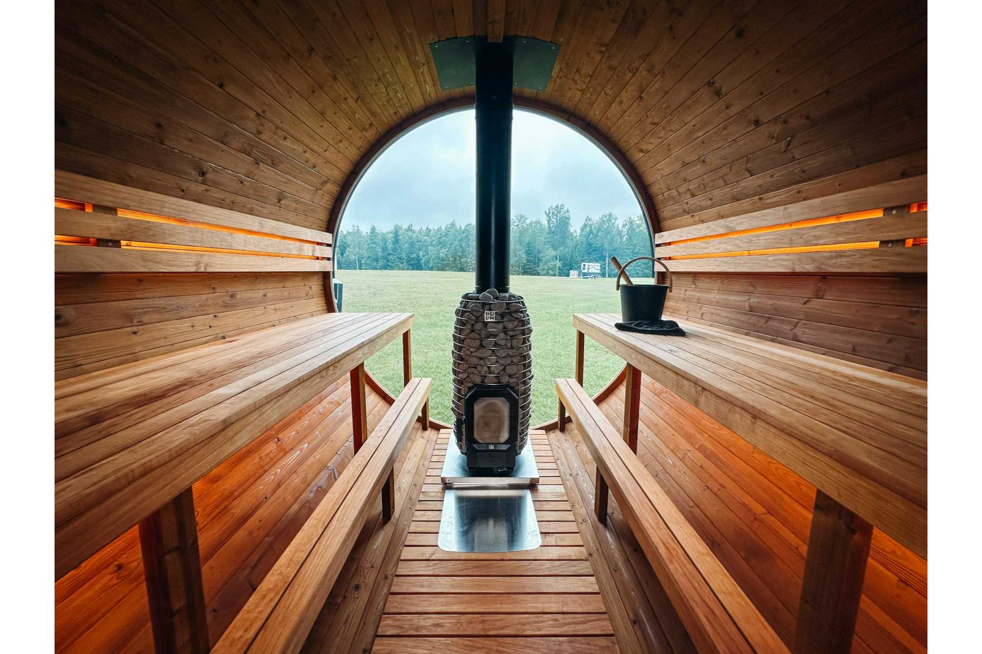 Interior view of an Outdoor Sauna Kit showing the wood burning sauna and landscape in the background