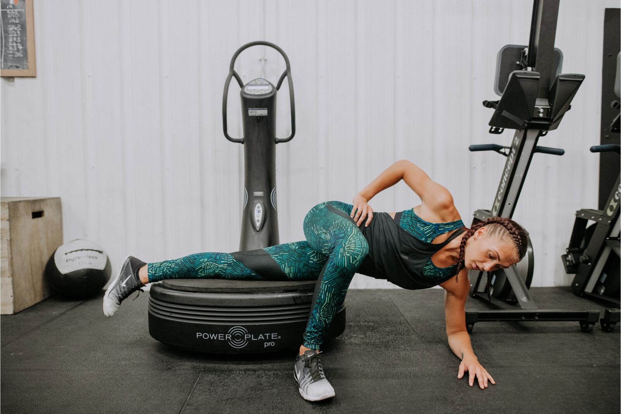 Woman doing a side plank on a power plate