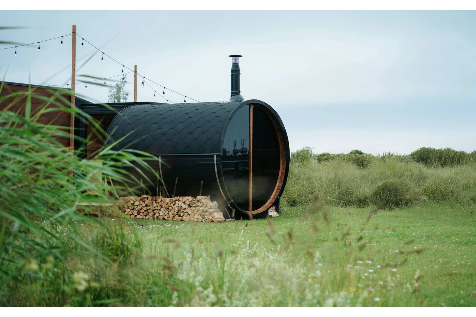 Outdoor Barrel Sauna in a landscape area showing the sauna chimney and shingles