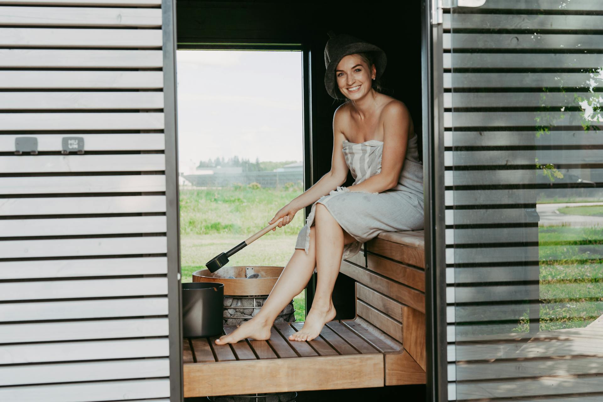 woman sitting inside a sauna and smiling