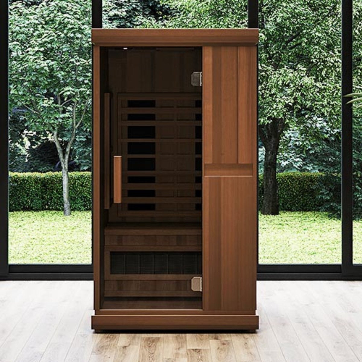 Finnmark FD-1 infrared sauna with a wooden exterior and glass door installed in a room with large windows overlooking greenery.