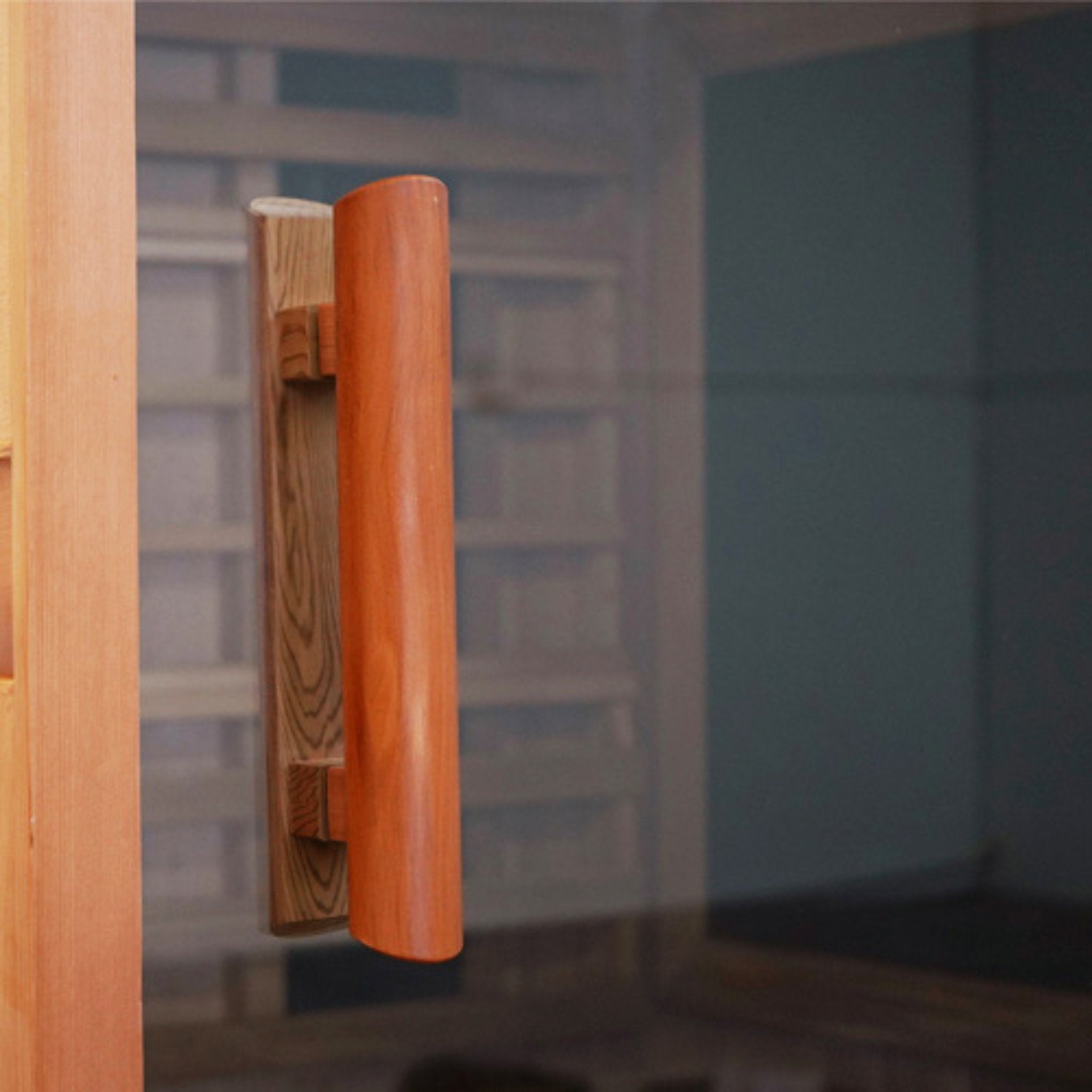 Close-up view of the Finnmark FD-1 infrared sauna wooden door handle with a blurred interior background.