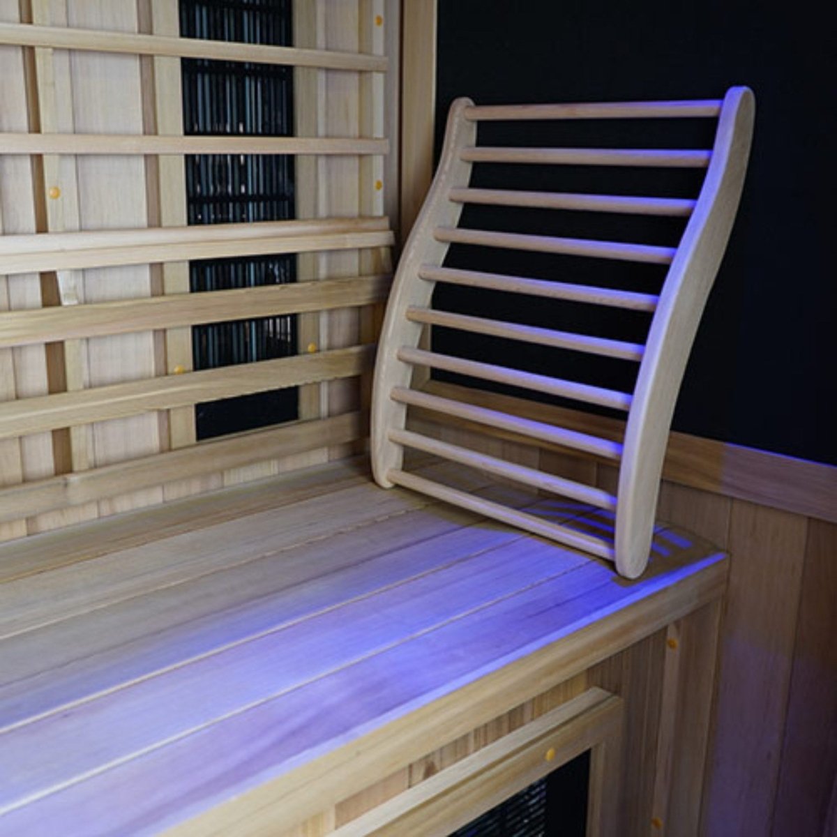 Close-up view of the Finnmark FD-2 infrared sauna interior showing a wooden bench, removable curved wooden backrest, and wood-panel walls on a white background.