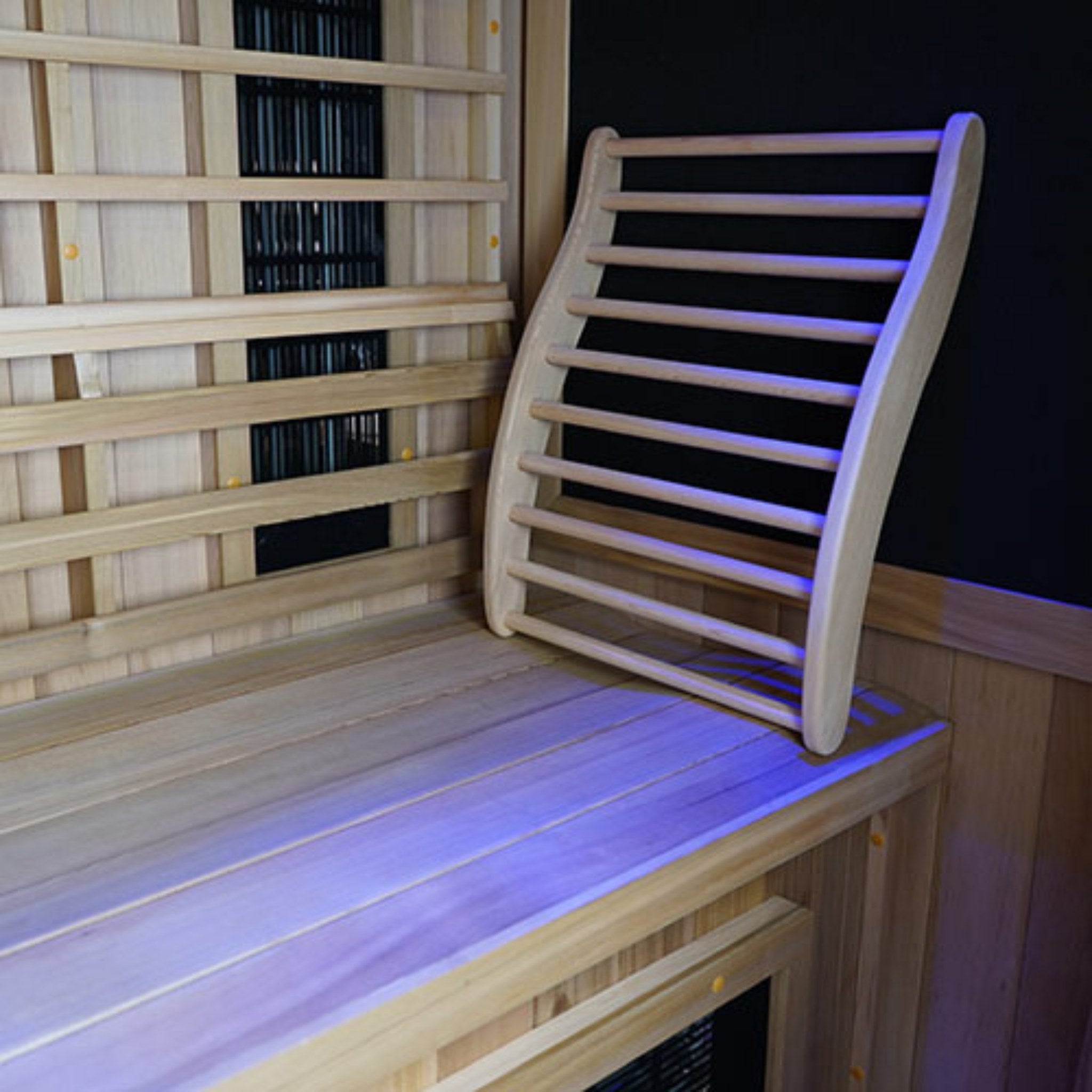 Close-up view of the Finnmark FD-2 infrared sauna interior showing a wooden bench, removable curved wooden backrest, and wood-panel walls on a white background.