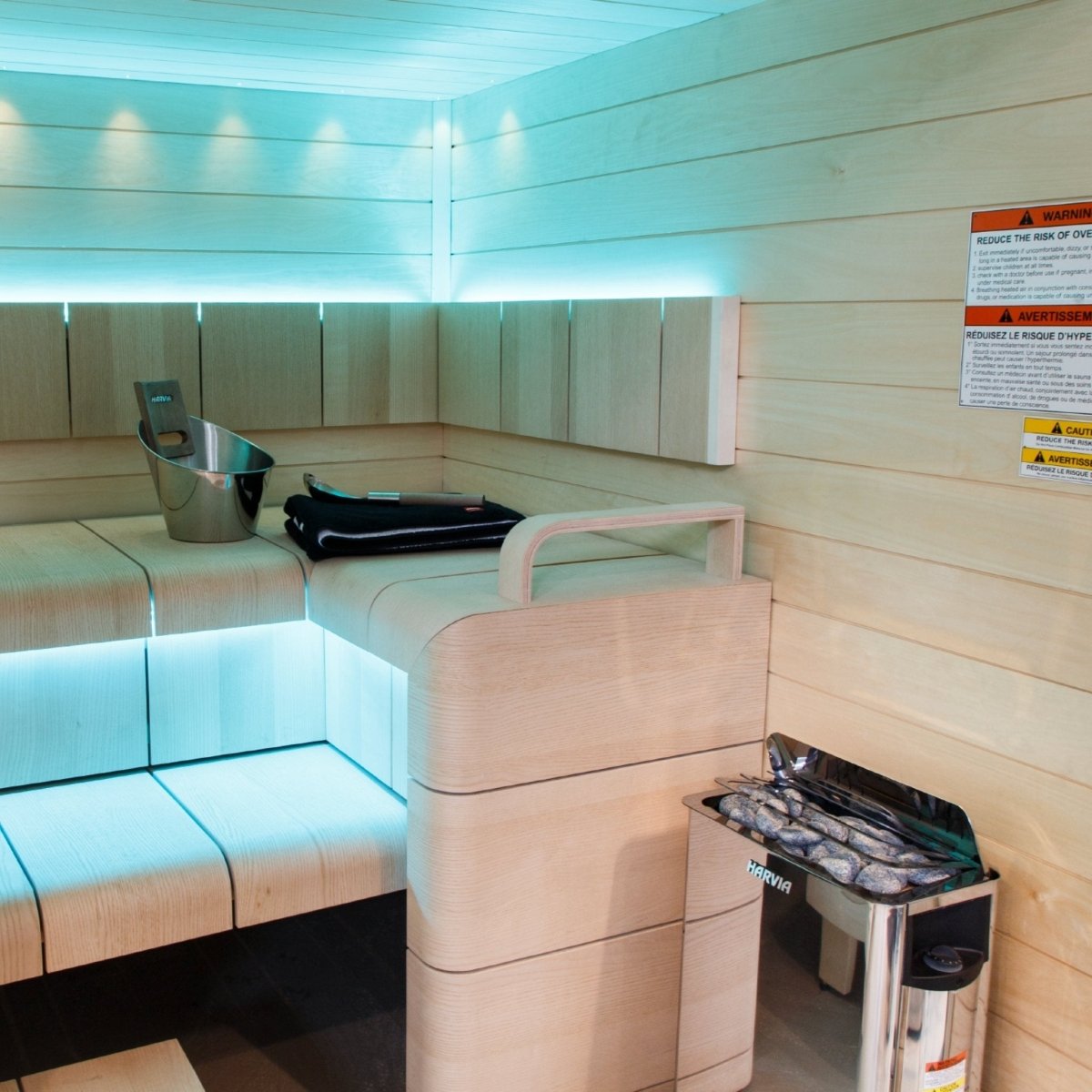 Harvia The Wall SWS60 electric sauna heater installed in sauna with warm ambient lighting