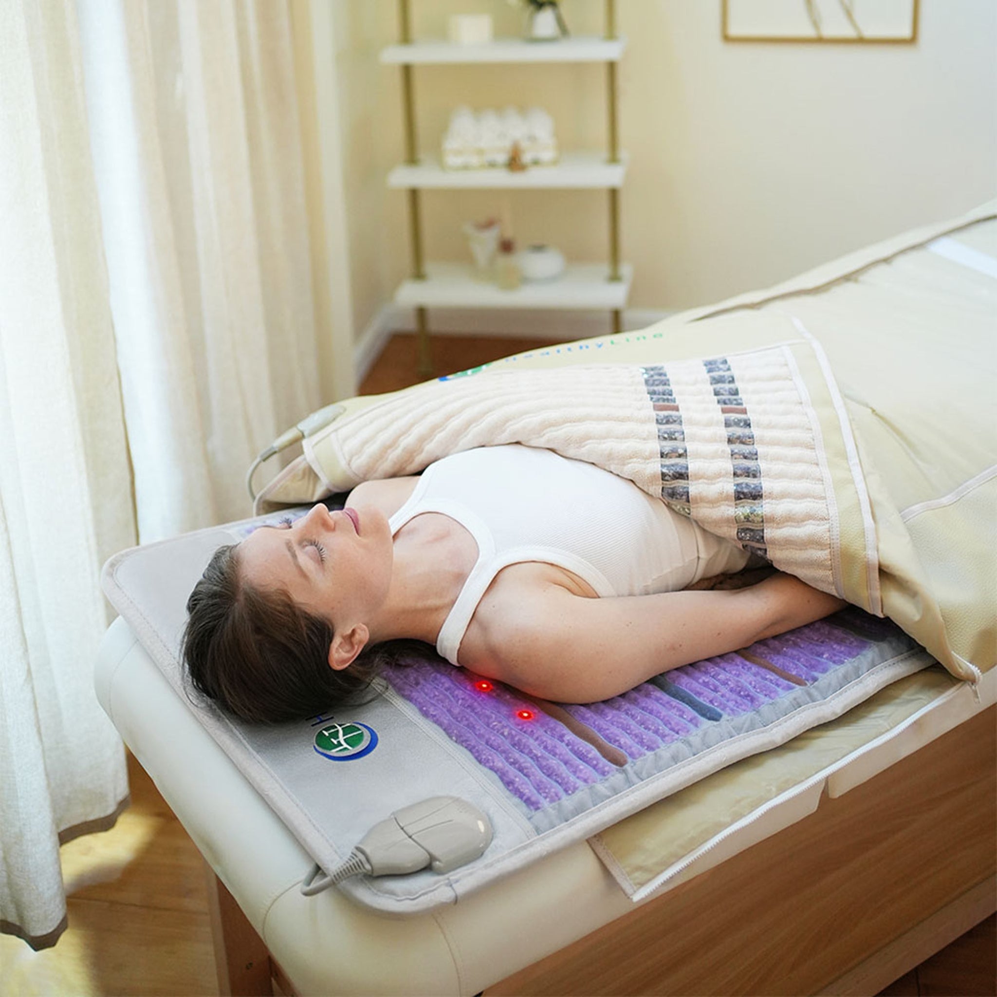 Woman relaxing on a HealthyLine Platinum PEMF Far Infrared Heating Mat with gemstones in a bedroom setting
