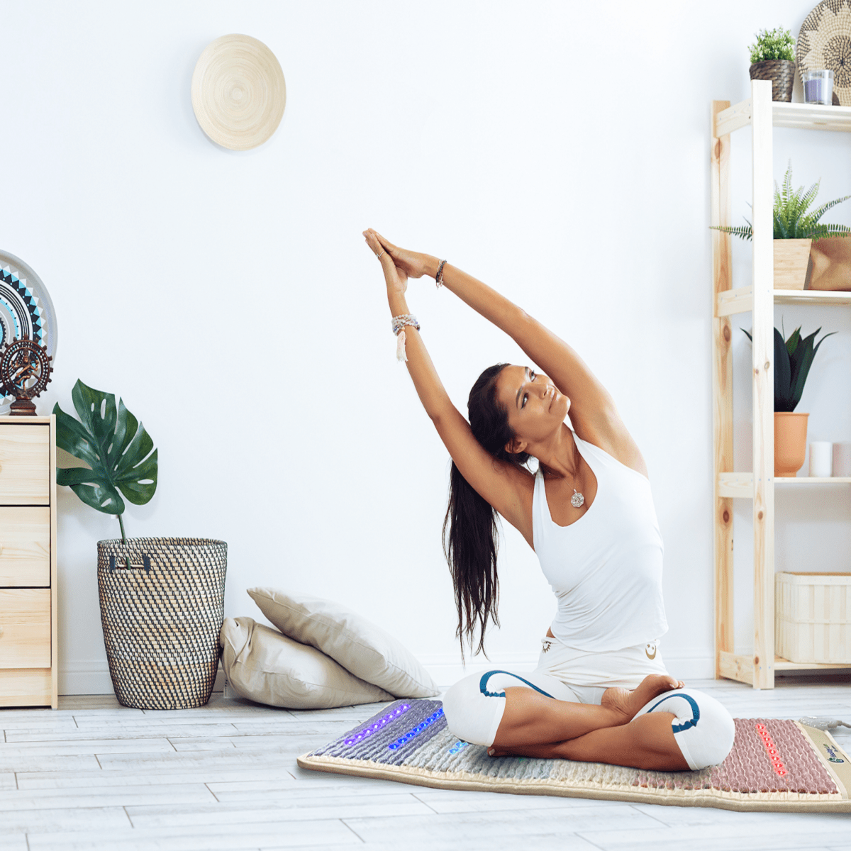 Woman practicing yoga on HealthyLine Rainbow Chakra Mat 7428 with PEMF, Far Infrared, and chakra gemstone therapy lights