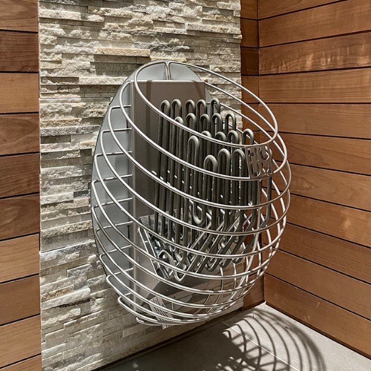 HUUM DROP 6 electric sauna heater installed against textured stone sauna wall.