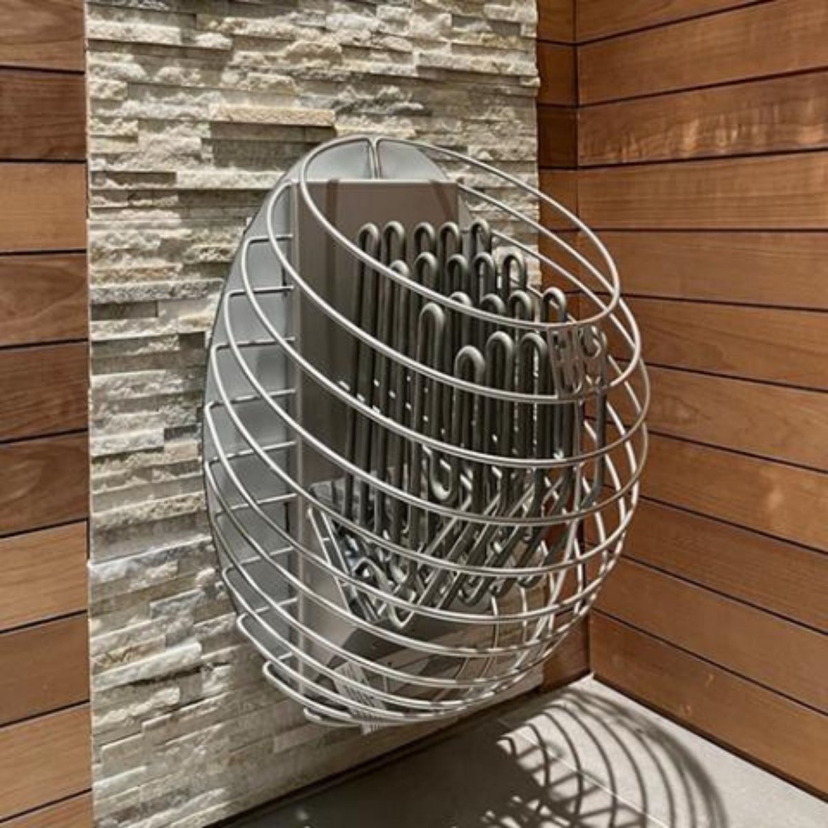 HUUM DROP 9 sauna heater installed against stone sauna wall
