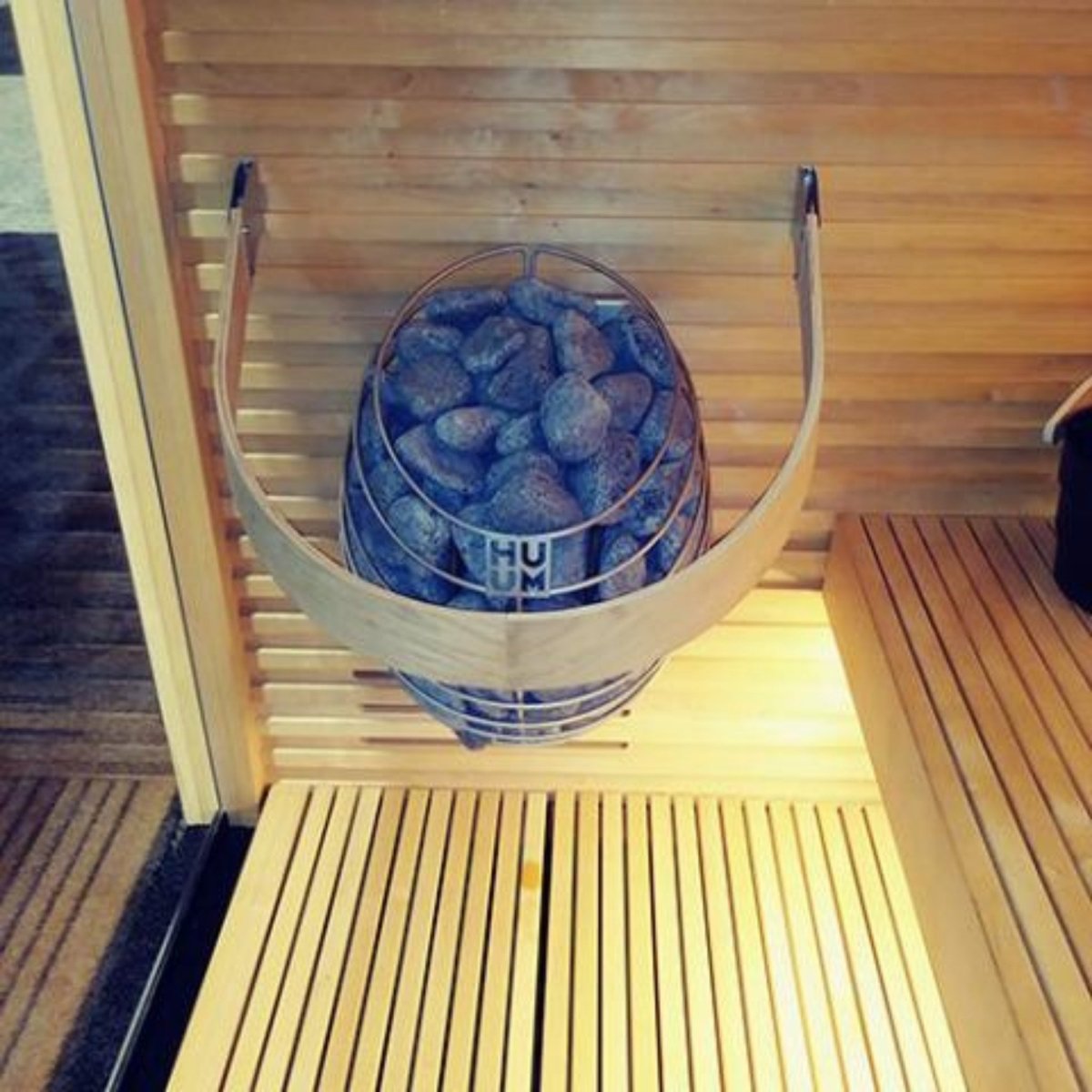 HUUM DROP 9 sauna heater with safety railing inside a sauna