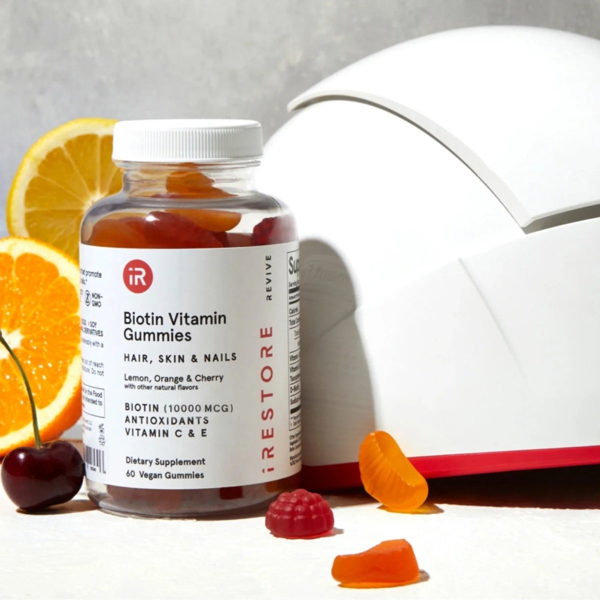 iRestore Biotin Gummies bottle displayed with book and scattered gummies