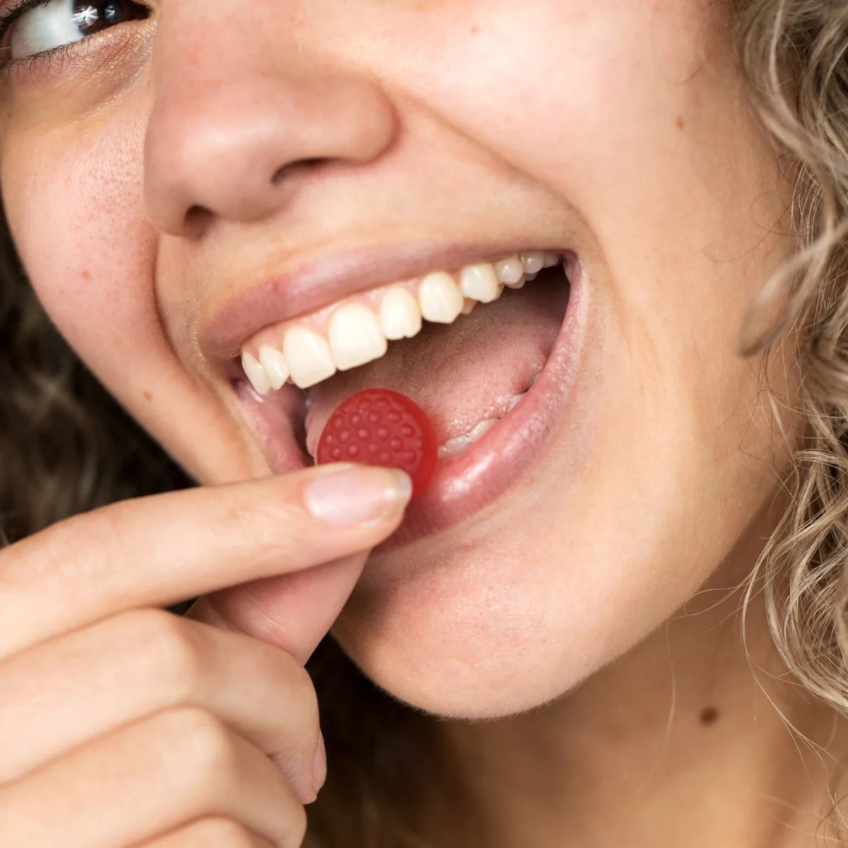 Woman enjoying iRestore Biotin Gummy supplement for stronger hair growth