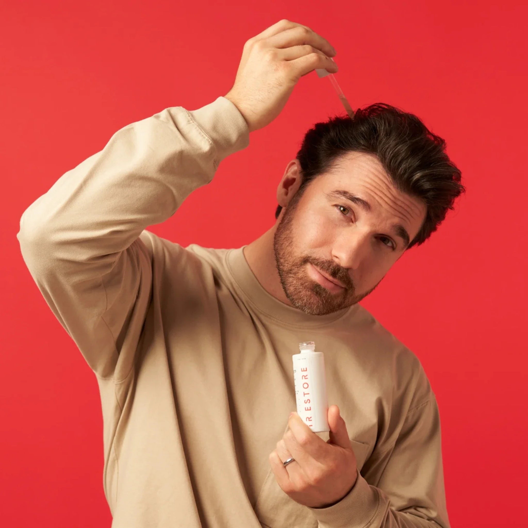 Man applying iRestore 3-in-1 Hair Growth Serum directly to scalp