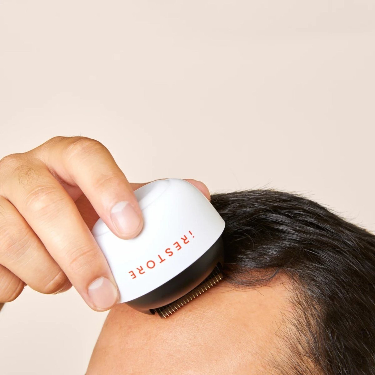 iRestore scalp massager shown with charging base and accessories