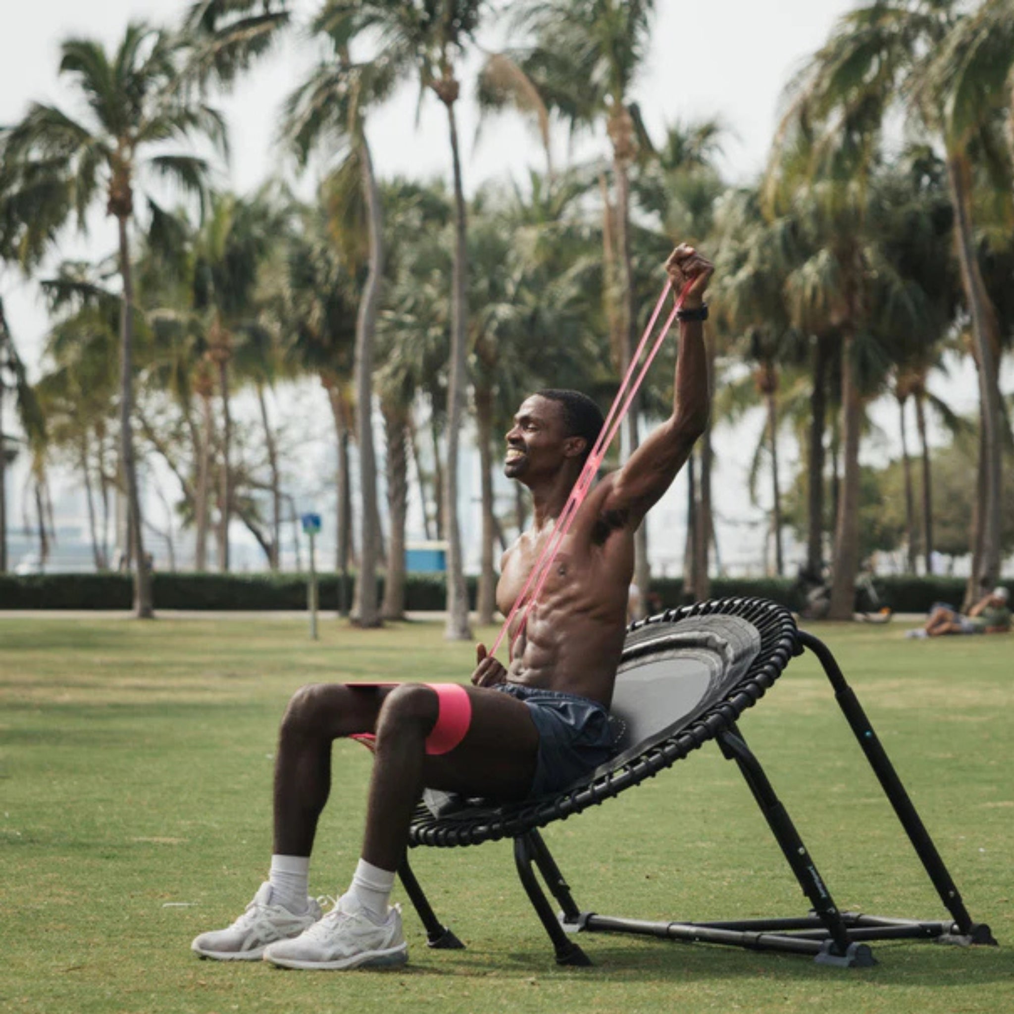 Woman training outdoors with Jumpsport resistance bands on fitness trampoline