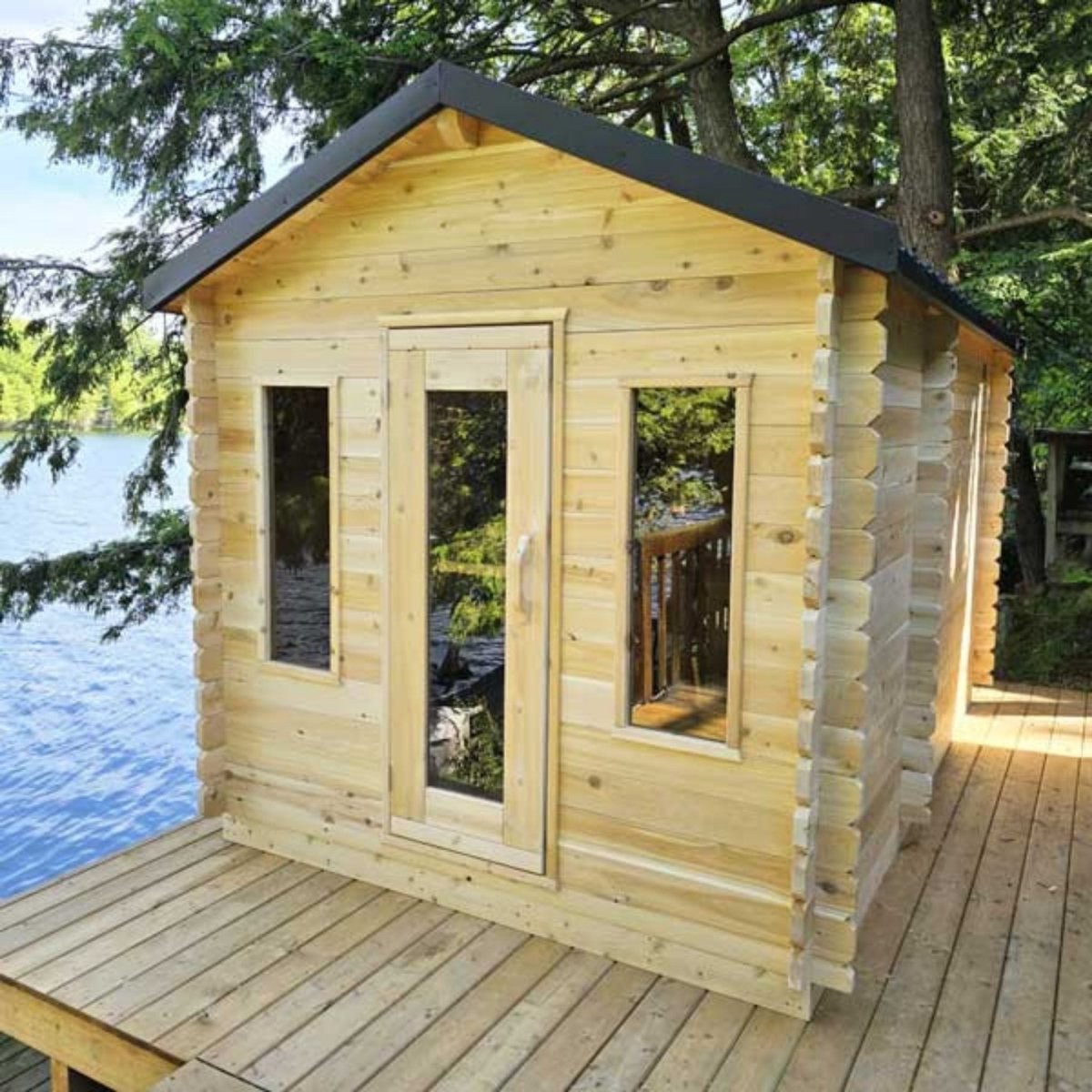 Leisurecraft CT Georgian Cabin Sauna with changeroom, Canadian cedar construction, installed by the lakeside with trees nearby.