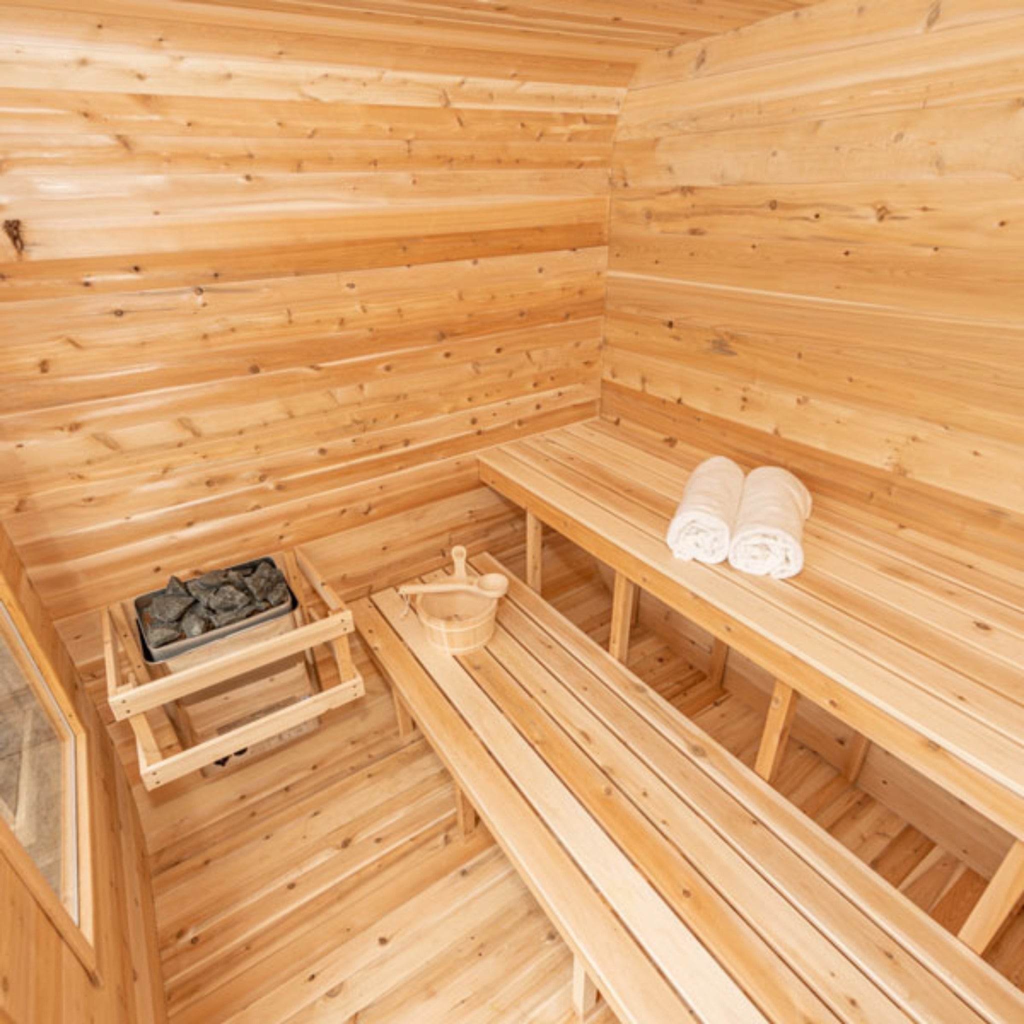 Leisurecraft CT Luna sauna interior with Canadian cedar benches, wooden bucket, and rolled towels.