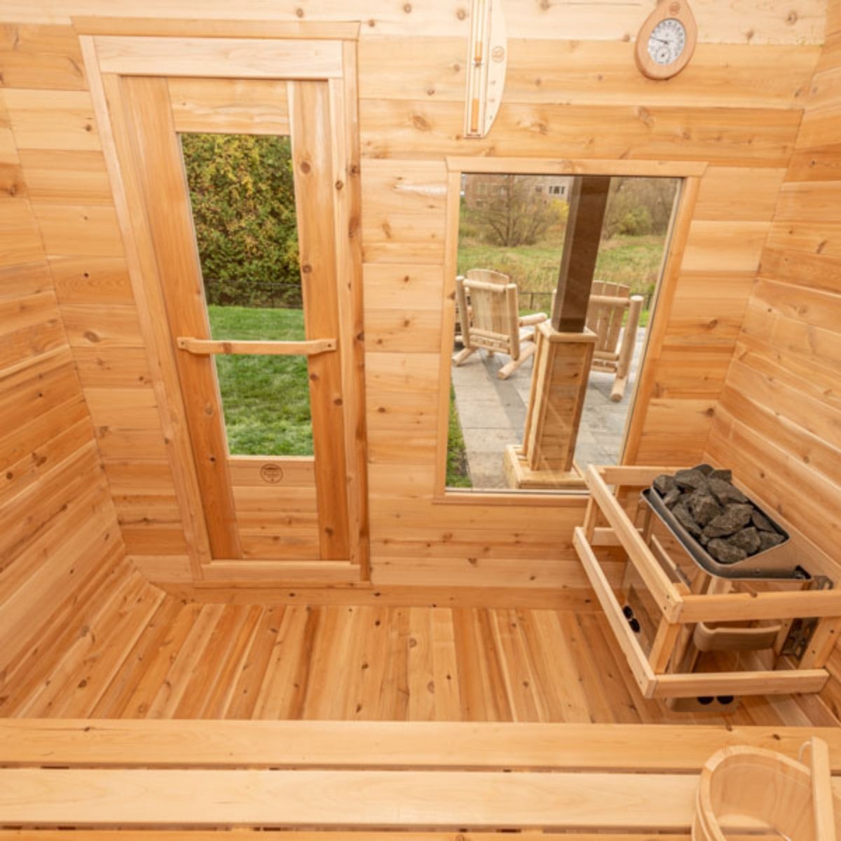 Leisurecraft CT Luna sauna interior with cedar benches, glass door, window, and heater for cozy relaxation.