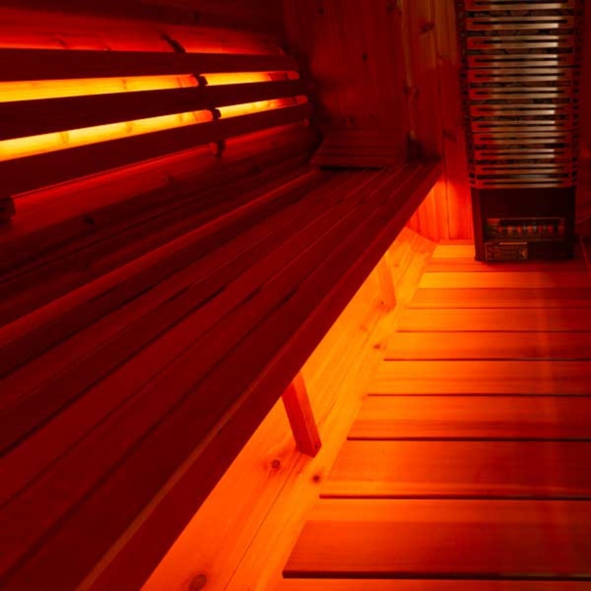 Leisurecraft single bench set inside sauna with smooth cedar wood and warm red ambient lighting