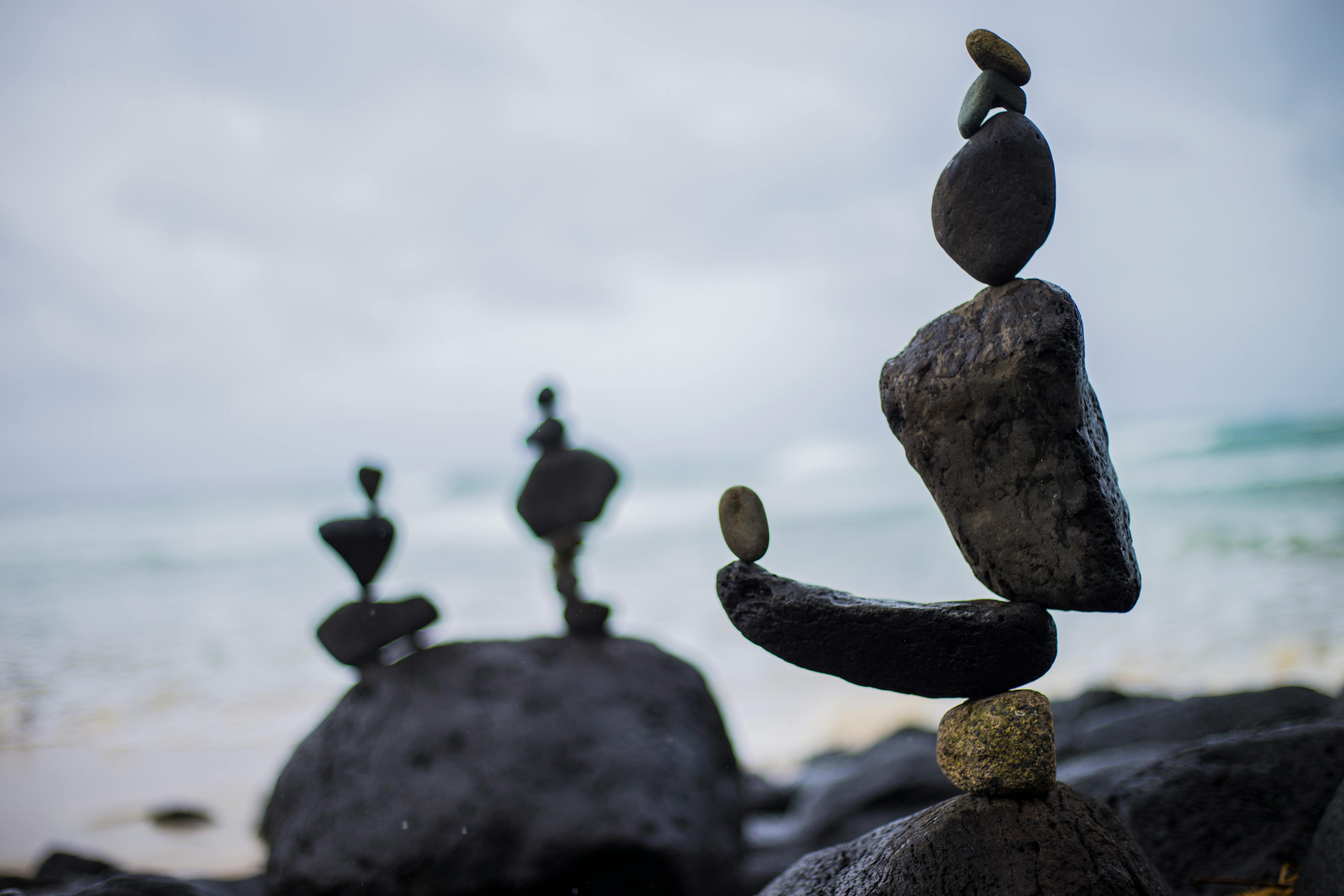 Balanced stones by the ocean representing wellness, mindfulness, and intentional living at My Energy Flow