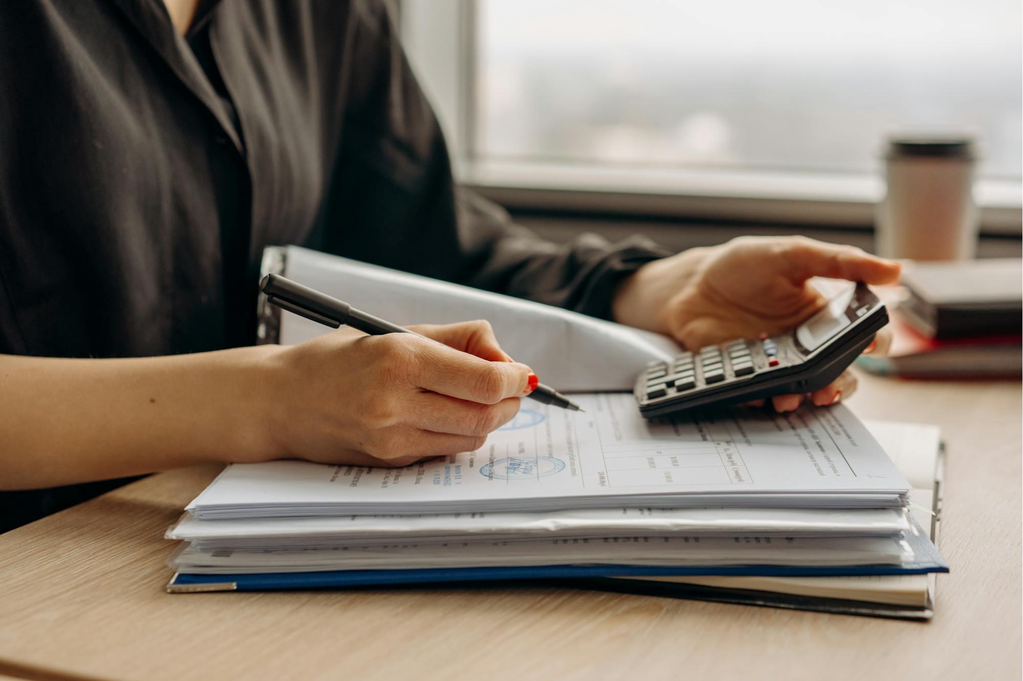 Person calculating wellness modality ROI and business investment costs at a desk