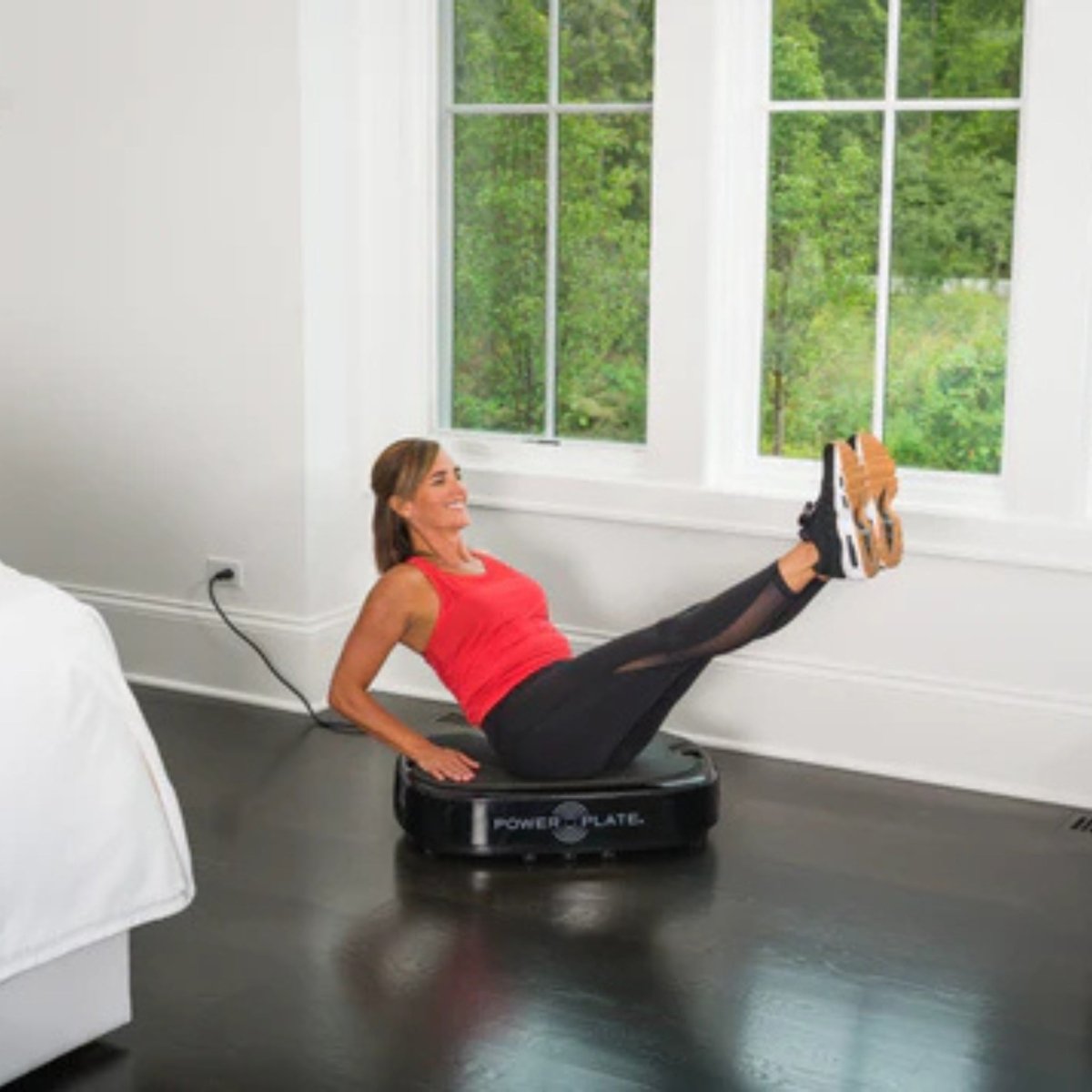 Man performing leg workout on Power Plate Personal vibration platform at home