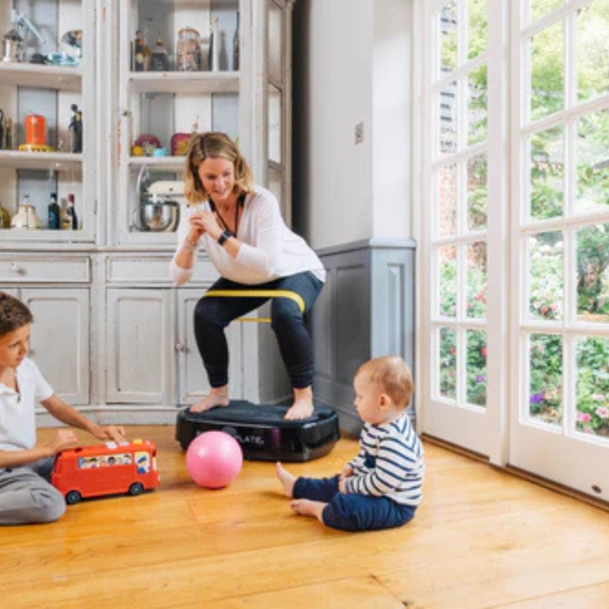 Woman using Power Plate Personal vibration platform for yoga and flexibility exercises