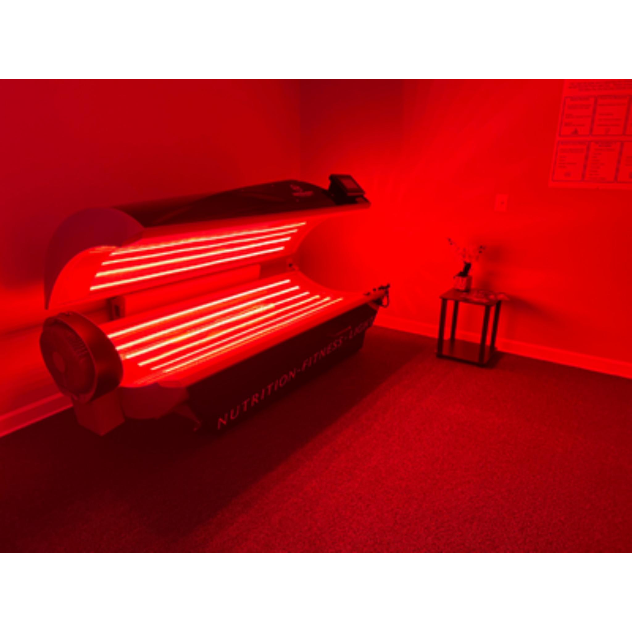 Prism Light Pod open with glowing red light therapy panels in a treatment room for recovery and wellness