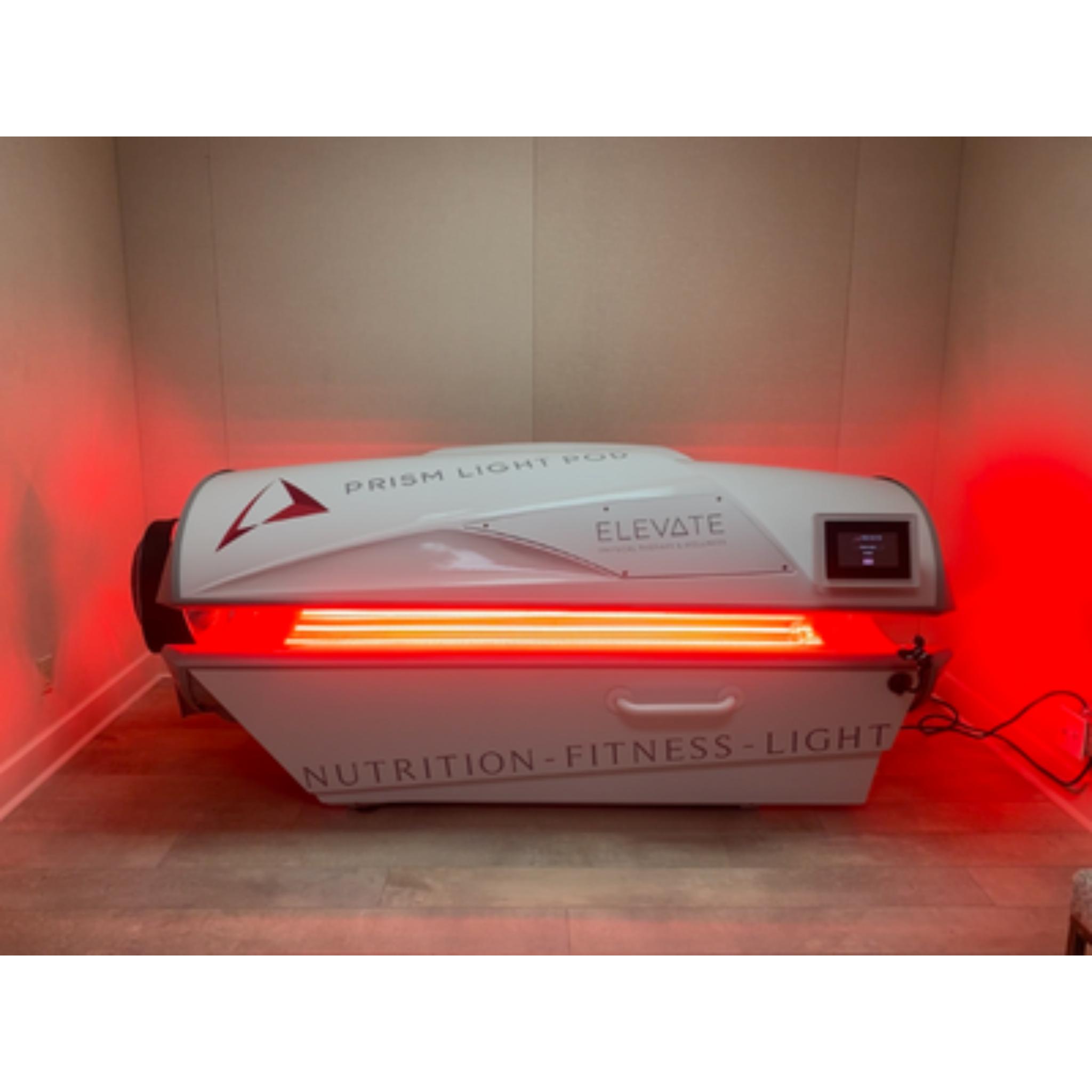Prism Light Pod closed system with red light therapy panels glowing in a treatment room for recovery and wellness