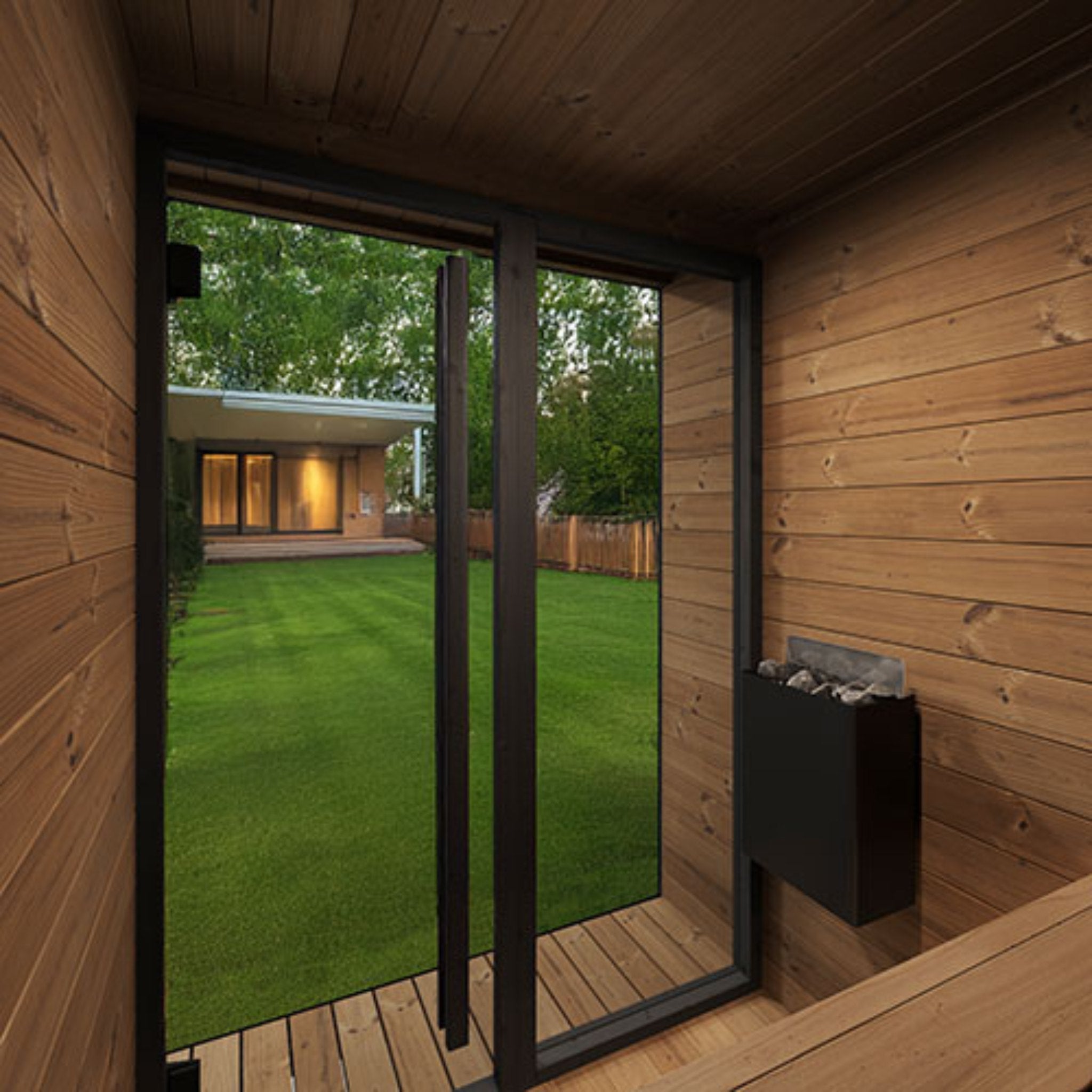 SaunaLife GL4 outdoor sauna cabin beside modern home with large glass windows.