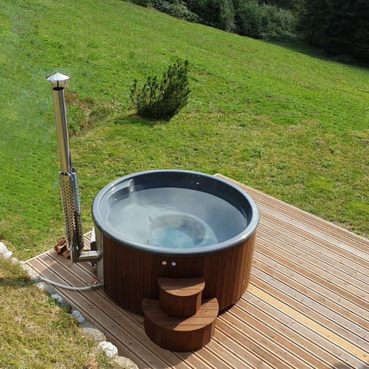 Round SaunaLife S4N hot tub installed on wooden deck with elevated hillside view.