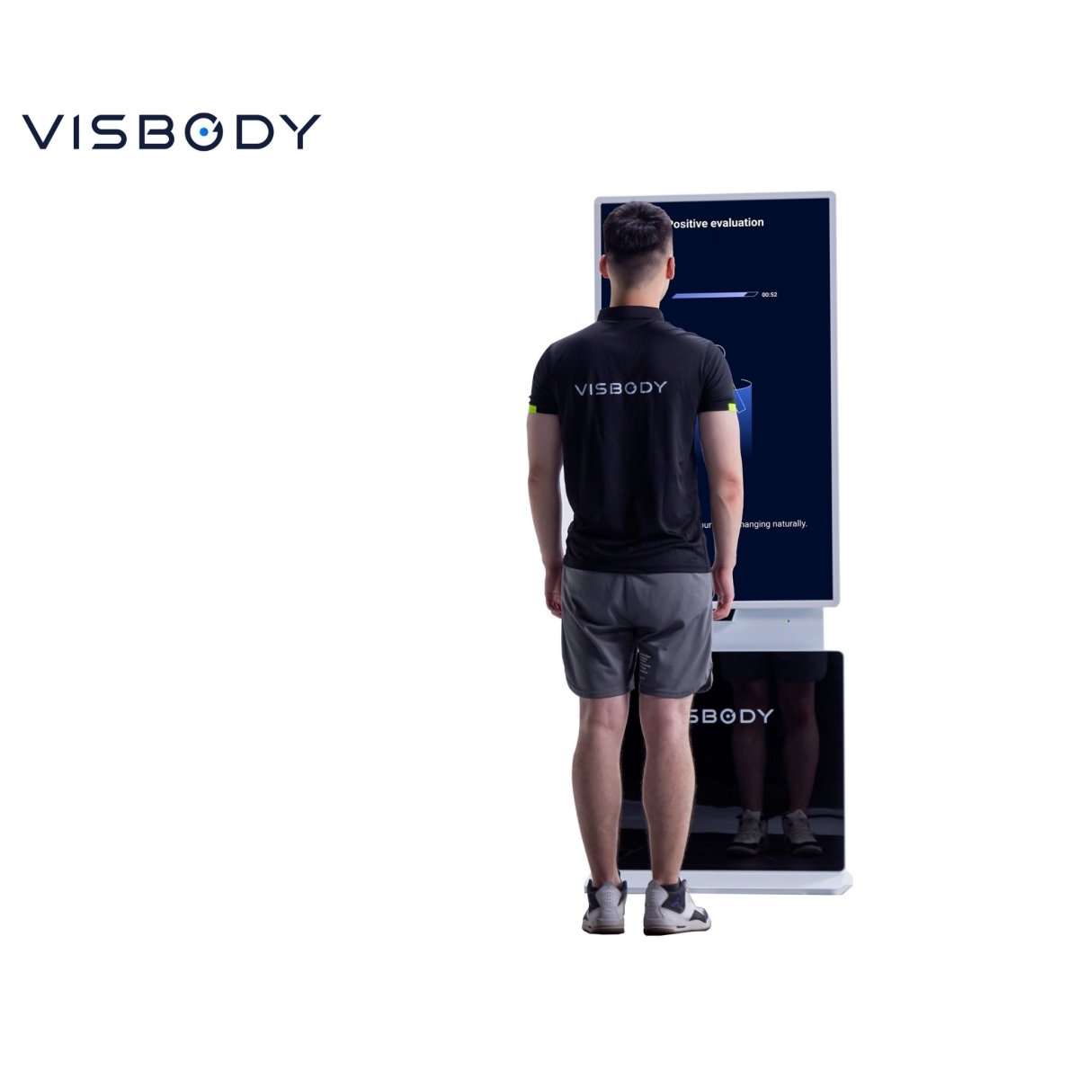 Man standing in front of the Visbody T30 3D body scanner during posture and body composition analysis demonstration on a white background