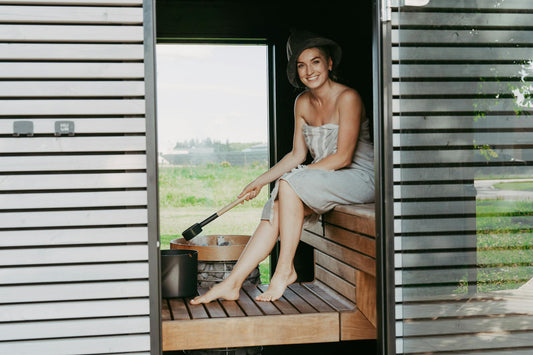 woman sitting inside a sauna and smiling
