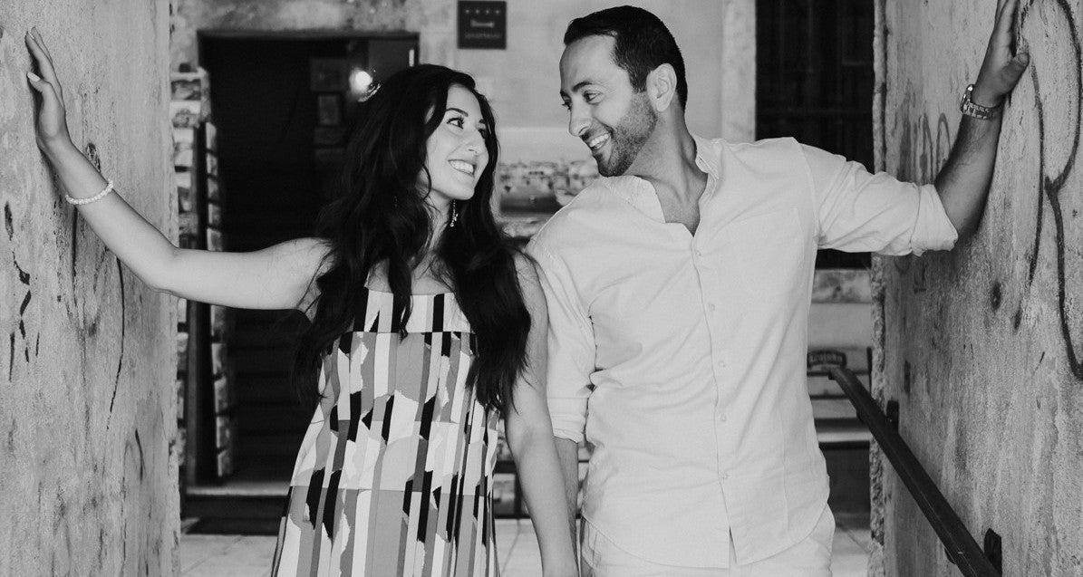 Black and white photo of a couple posing together in an indoor setting.