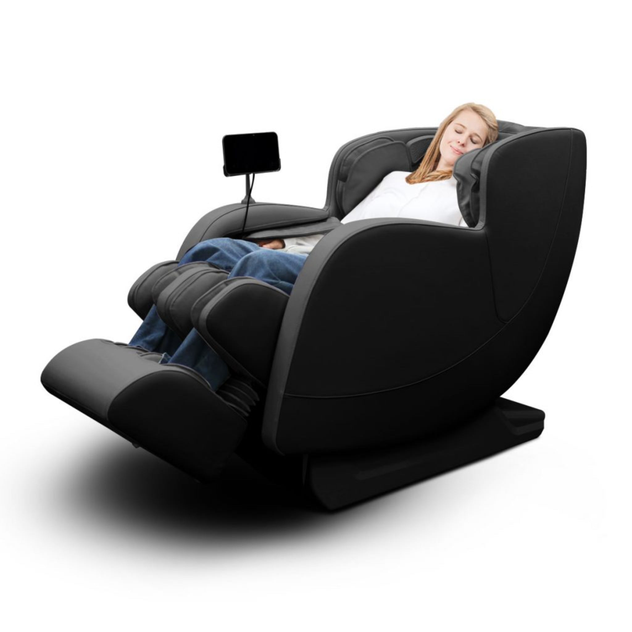 Woman reclining in a sleek black kahuna massage chair with footrest, designed for full-body relaxation and comfort on a white background