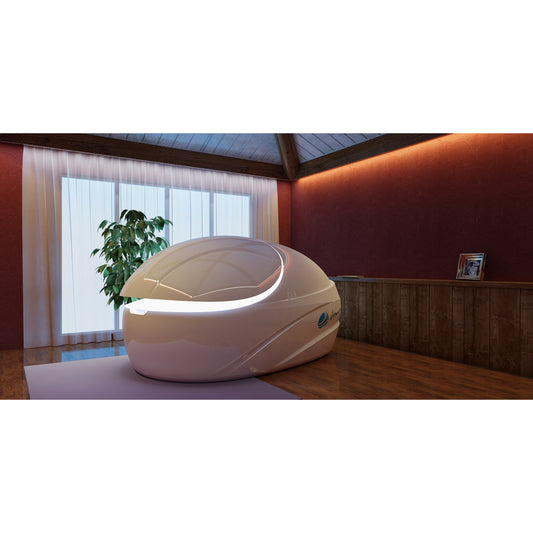 Dreampod float pod with white finish and LED accent lighting, placed in a serene wellness room with wood flooring, warm walls, and natural light for relaxation therapy