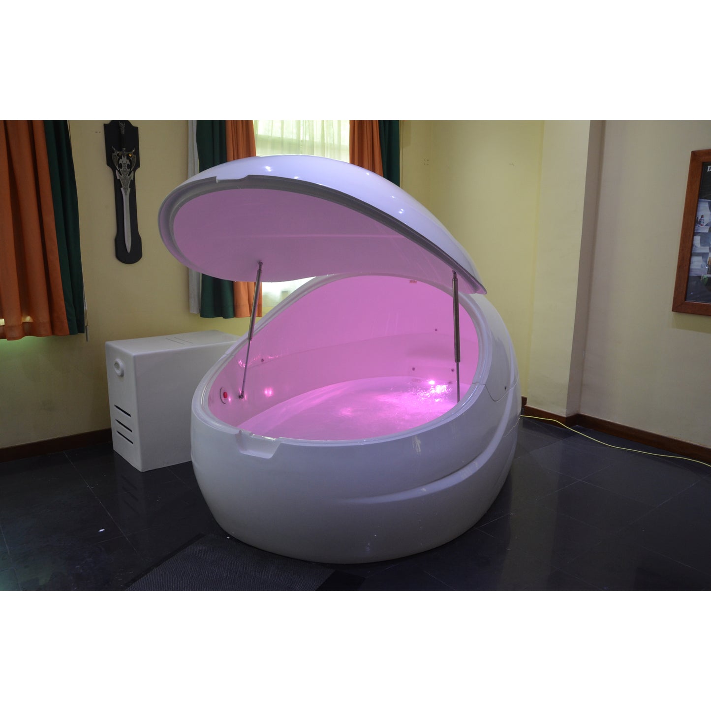 Dreampod float pod with sleek white finish and open canopy lid, illuminated with soft pink LED lighting, placed in a cozy wellness room with curtains and ambient décor for relaxation therapy
