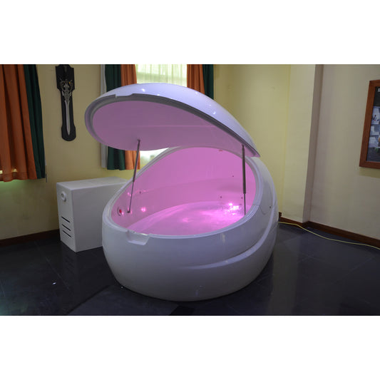 Dreampod float pod with sleek white finish and open canopy lid, illuminated with soft pink LED lighting, placed in a cozy wellness room with curtains and ambient décor for relaxation therapy