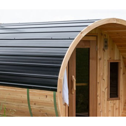 Close-up of a Leisurecraft barrel sauna with a black metal roof and cedar wood exterior, set outdoors