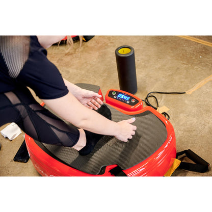 Close-up of a person using a red Power Plate MOVE vibration plate with a digital display during a workout session