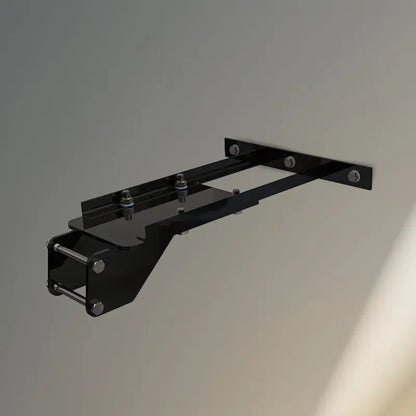 VersaClimber H/HP wall mount installation bracket in black steel finish, displayed against a neutral gray wall background, highlighting durable construction and secure mounting design