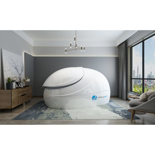 Sleek white float pod with canopy lid placed in a modern wellness room with large windows, wood flooring, and contemporary décor