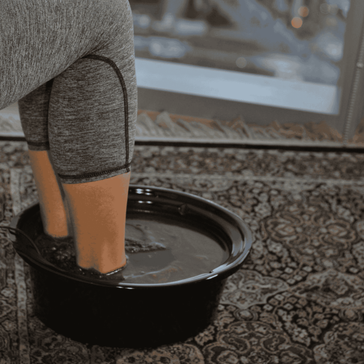 ReviveCleanse BASIC ionic foot bath system displayed next to a chair in a home setting