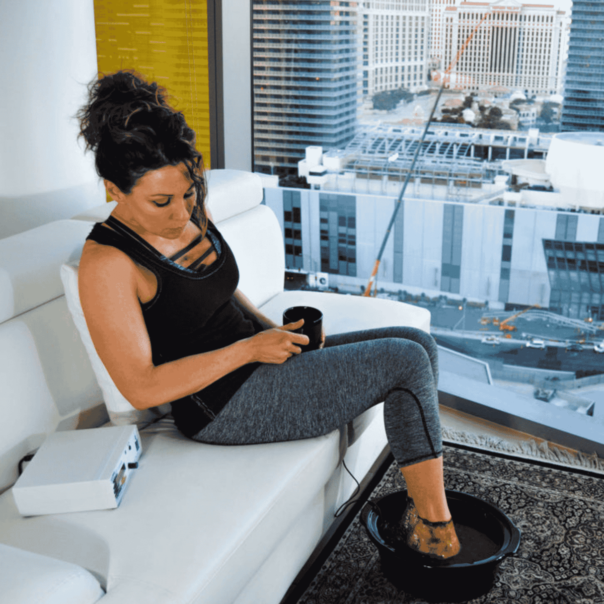 Person seated using the ReviveCleansePRO ionic foot bath with basin and digital control unit visible