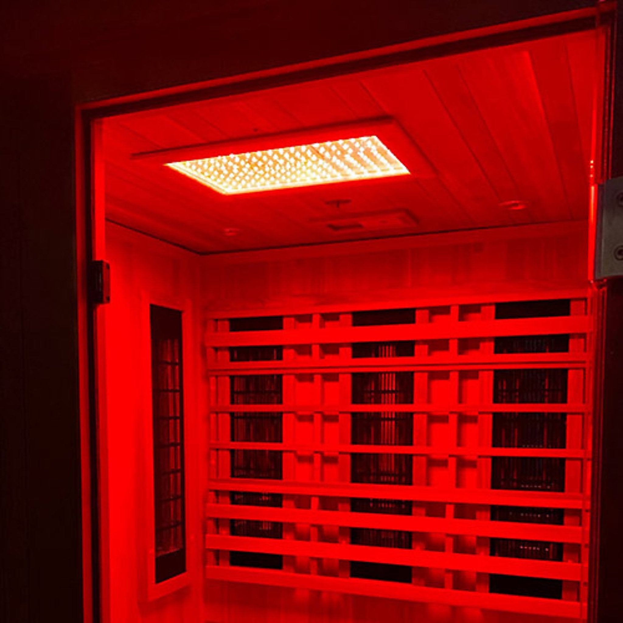 Finnmark FD-4 infrared sauna interior illuminated by red light heating panels for deep therapy.