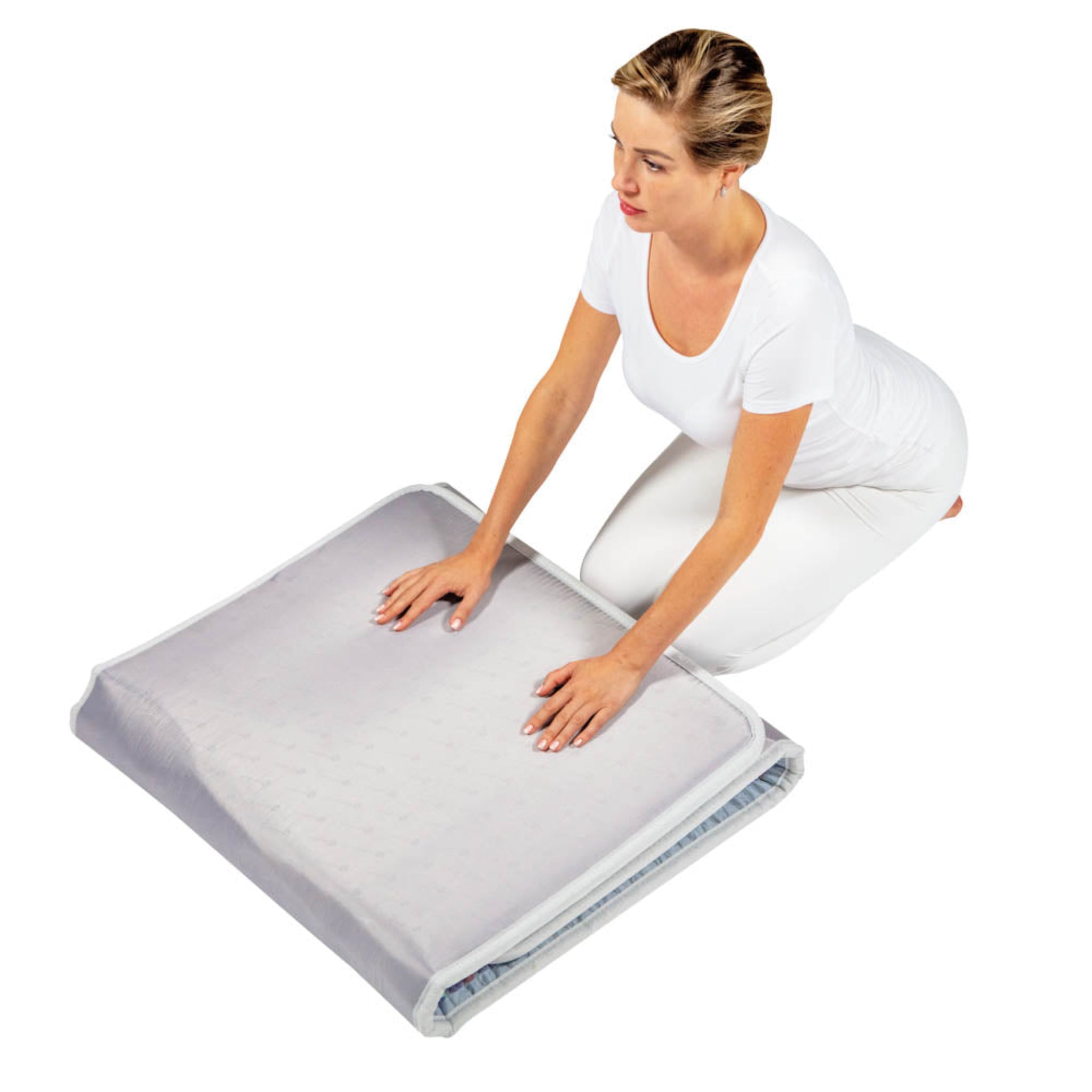 Woman folding a HealthyLine Platinum PEMF Far Infrared Heating Mat with protective cover for storage