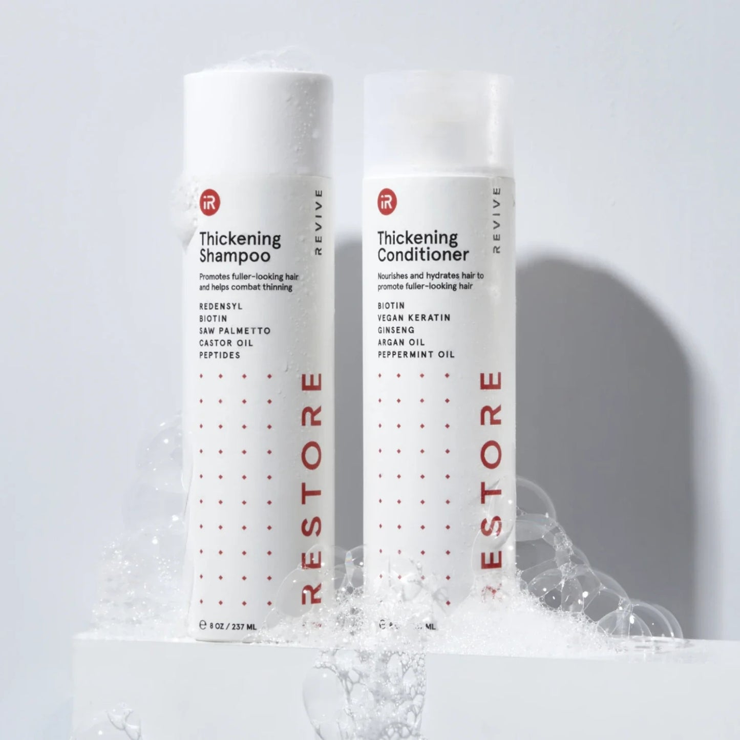 Two bottles of iRestore Anti-Thinning Shampoo shown on blue background