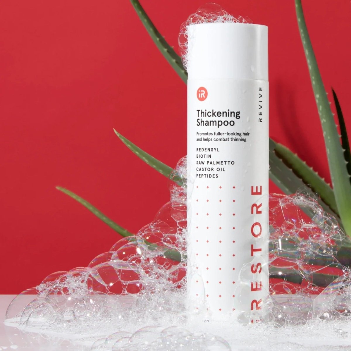 iRestore Anti-Thinning Shampoo bottle displayed on red background with bubbles
