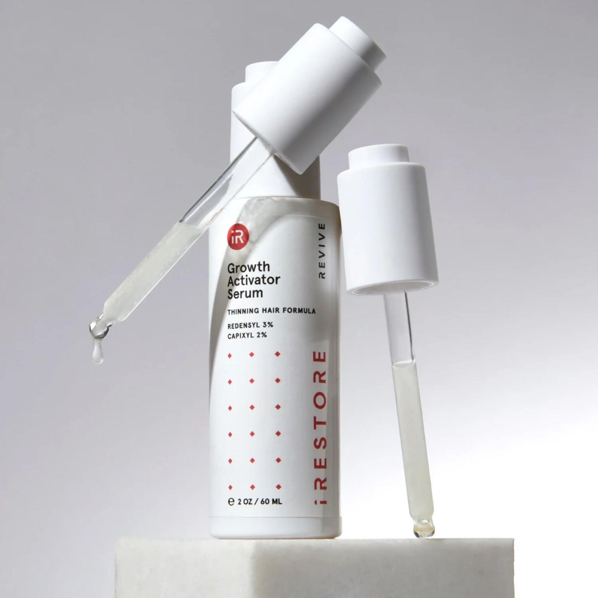 iRestore Hair Growth Serum bottle styled with flowers for natural hair care