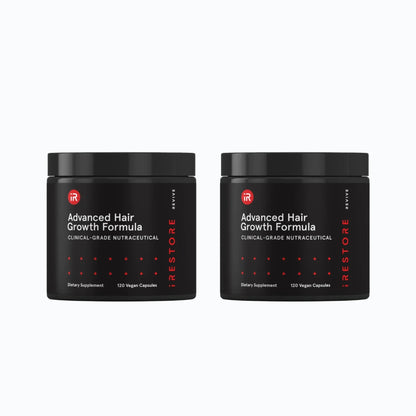 Hand placing iRestore Revive Advanced Hair Growth Formula supplement jar on table